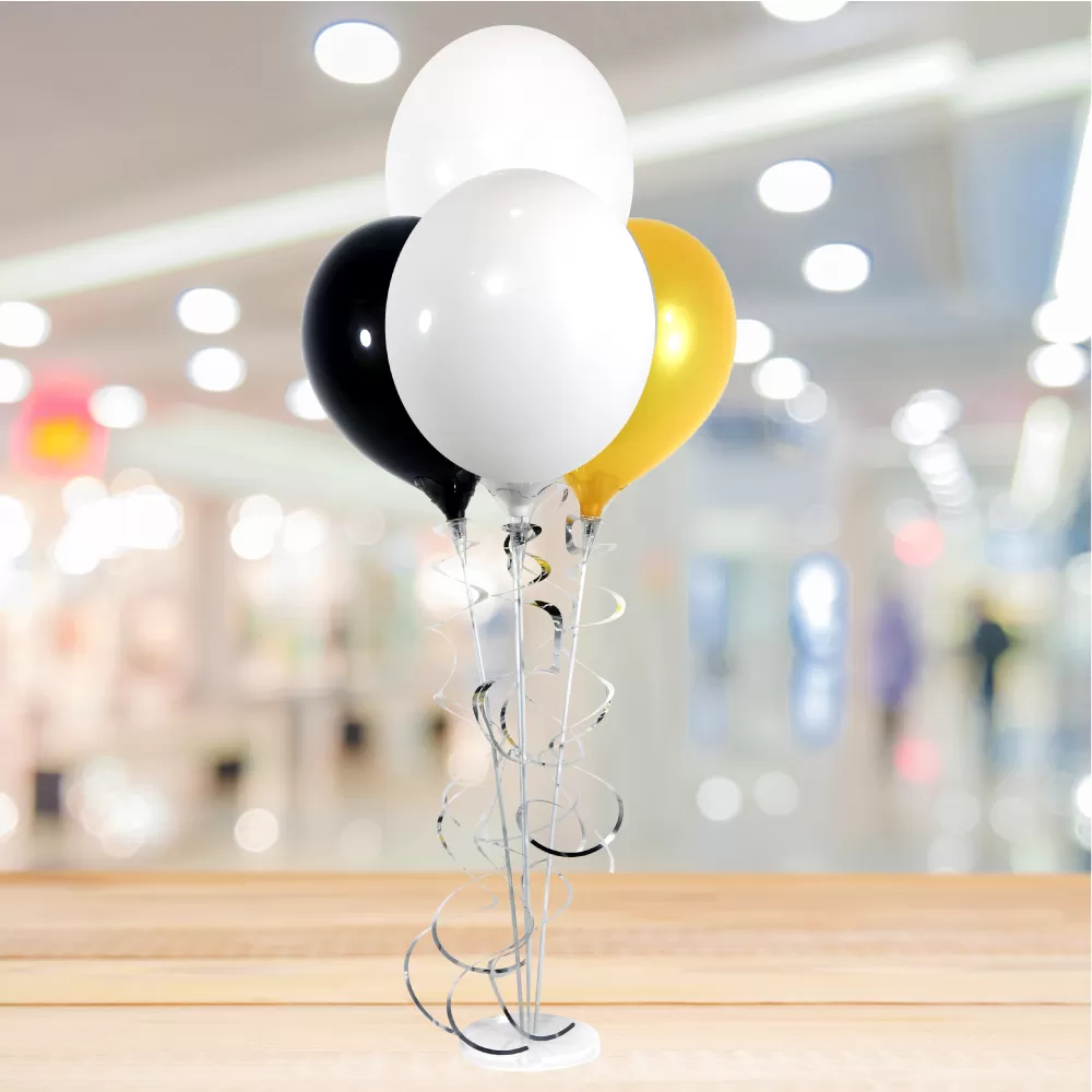 Four PermaShine balloons in white, black and gold on a clear acrylic weighted base