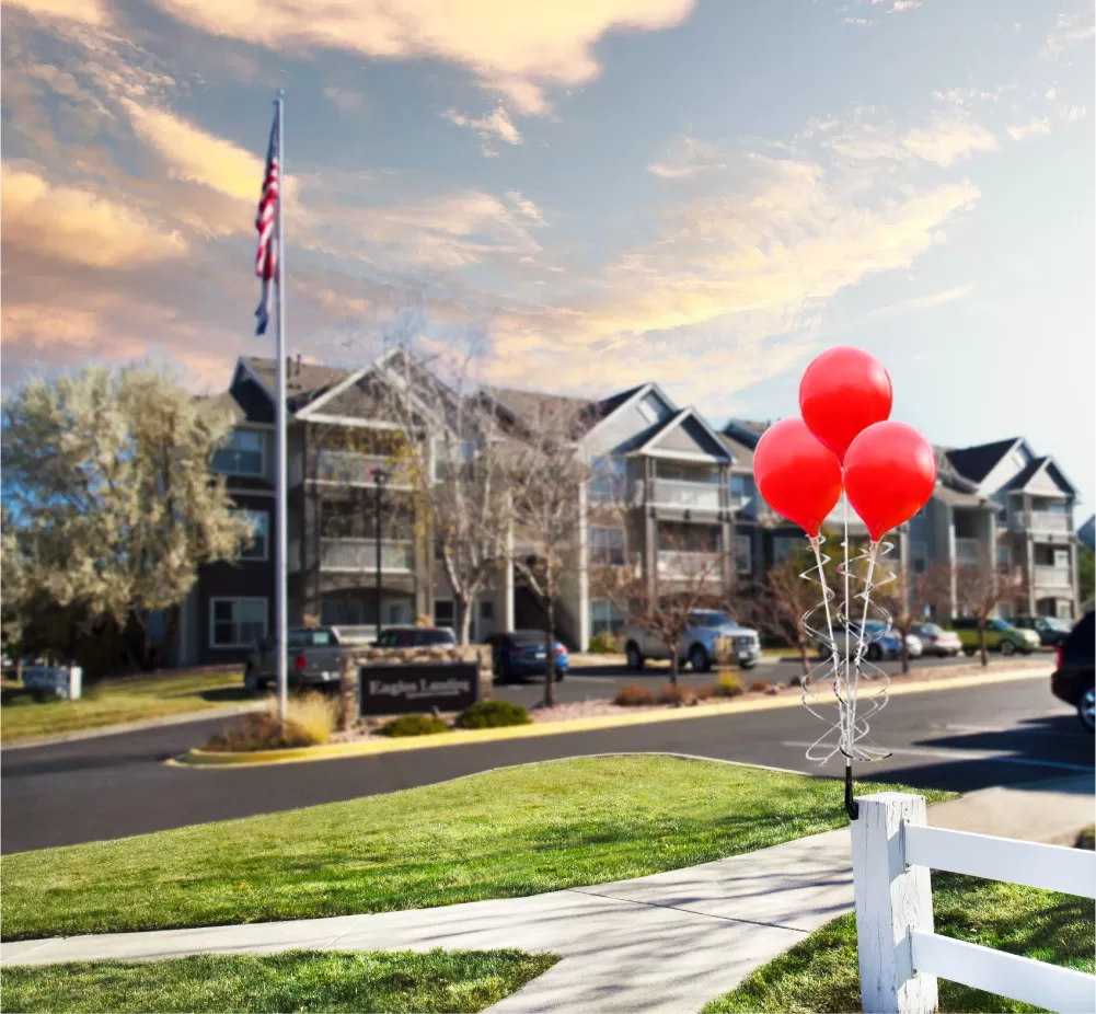 Three red PermaShine balloons on an upright bracket attached to a fence post