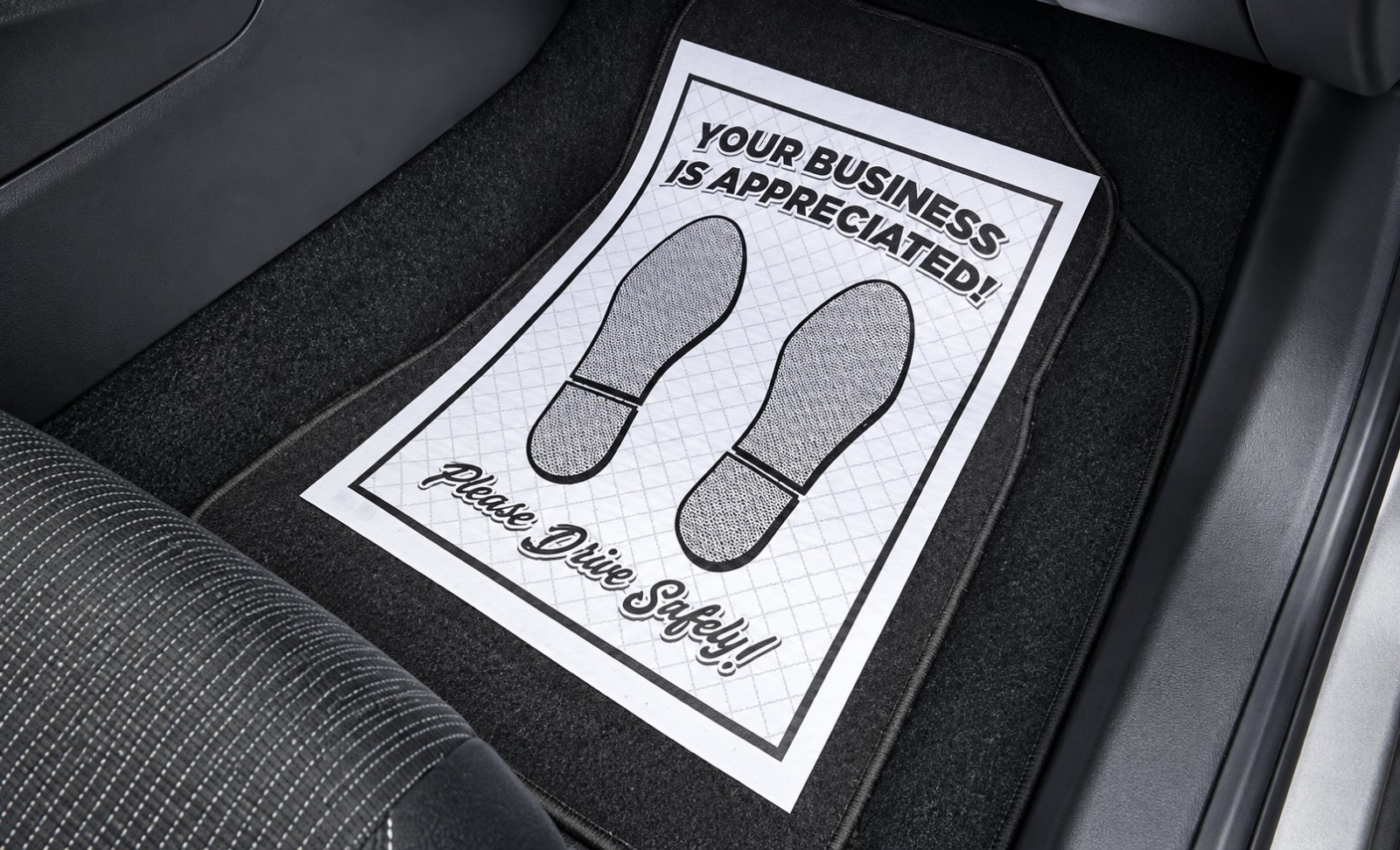 Ridged white paper floor mat with black footprints and Your Business Is Appreciated message