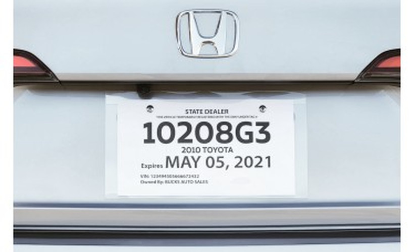Clear license plate protector jacket holding a printed temporary tag on a vehicle